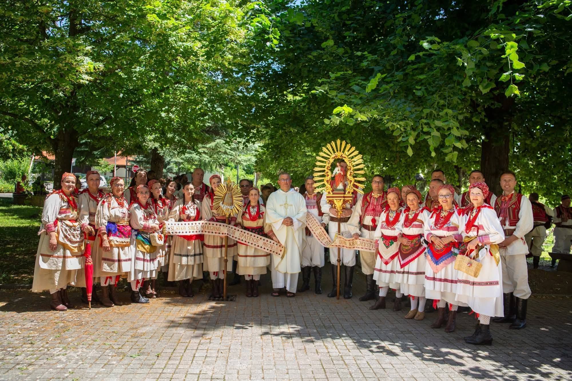 Cijela skupina KUD-a u sjeni lipa